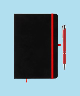Everyday Notebook and Pen set - Red. Matching pen and notebook trim on light blue background, 72 percent fit.
