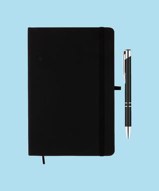 Everyday Notebook and Pen set - Black. Matching black pen and notebook trim on light blue background, 72 percent fit.